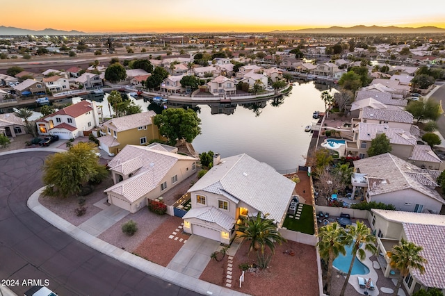 aerial view at dusk featuring a water view