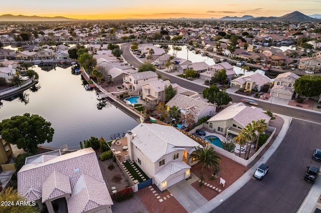 aerial view at dusk featuring a water view