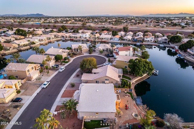 aerial view at dusk featuring a water view