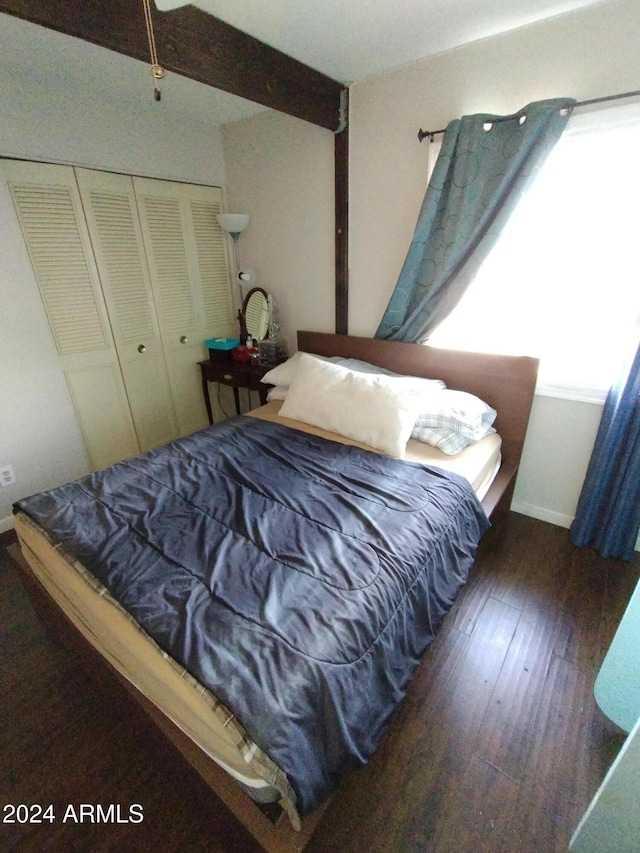 bedroom with dark hardwood / wood-style flooring and a closet