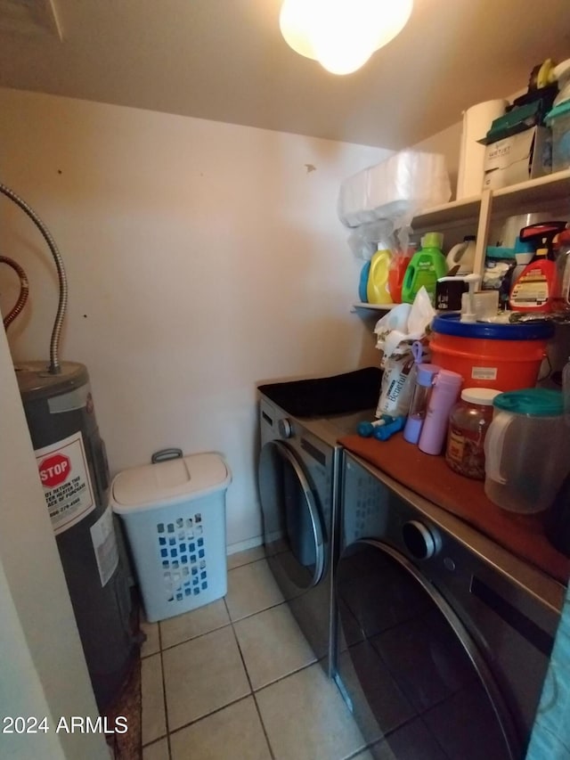 laundry room with electric water heater, light tile patterned floors, and washer and dryer