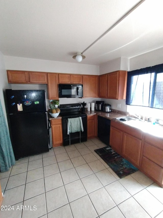 kitchen featuring light tile patterned floors and black appliances