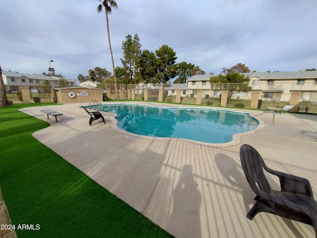 view of swimming pool with a yard and a patio area