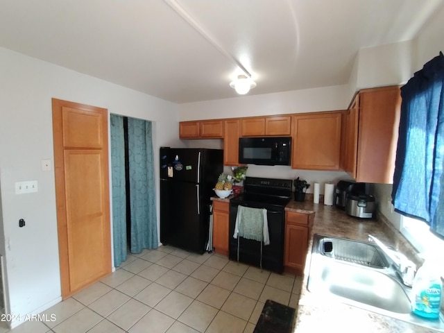 kitchen with light tile patterned floors, sink, and black appliances