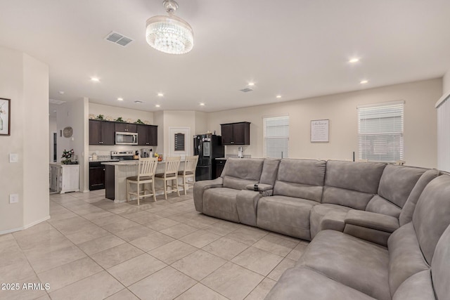 tiled living room featuring a notable chandelier