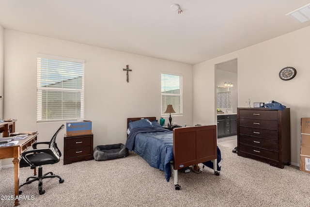 bedroom with light colored carpet and connected bathroom