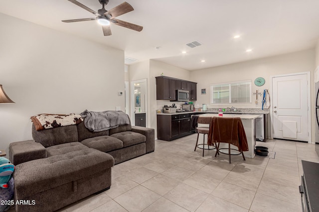 living room featuring sink, light tile patterned floors, and ceiling fan