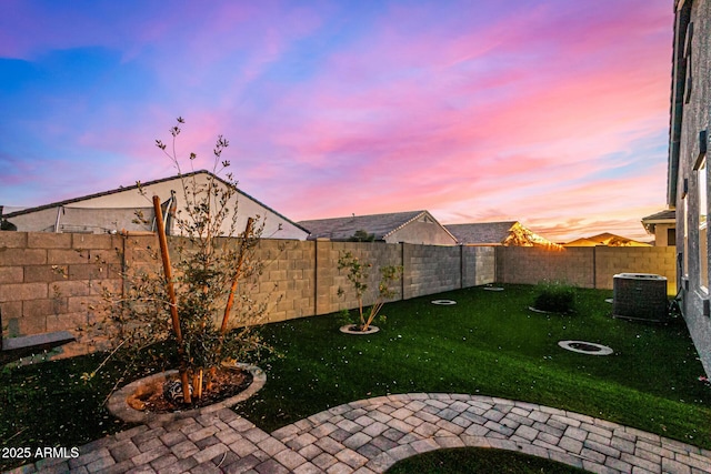 yard at dusk featuring central air condition unit