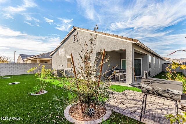 rear view of property with a yard and a patio area