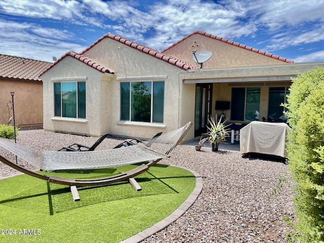 rear view of property with a yard and a patio area