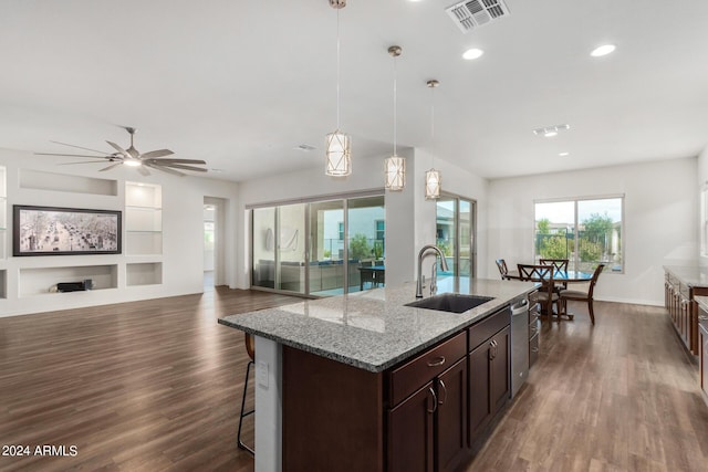 kitchen featuring light stone countertops, stainless steel dishwasher, ceiling fan, sink, and hanging light fixtures