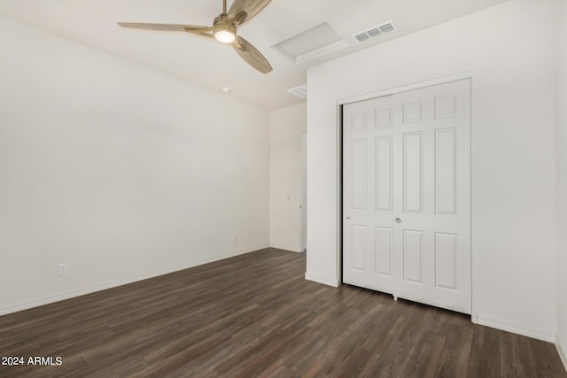 unfurnished bedroom featuring ceiling fan, dark hardwood / wood-style flooring, and a closet