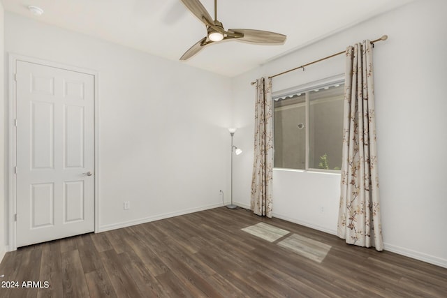 empty room with ceiling fan and dark wood-type flooring