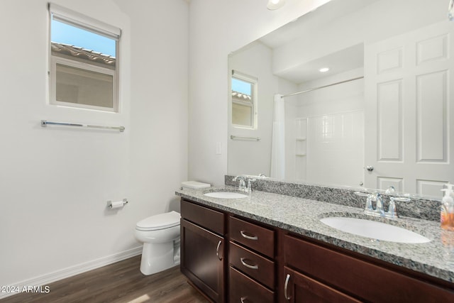 bathroom featuring walk in shower, vanity, wood-type flooring, and toilet