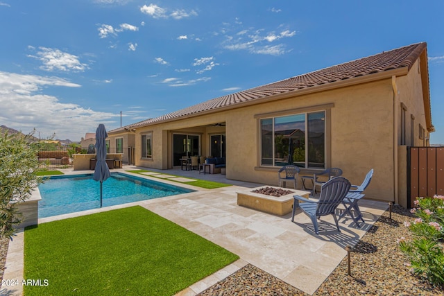 rear view of house with a patio and a fire pit