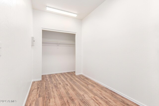 unfurnished bedroom featuring light hardwood / wood-style flooring and a closet