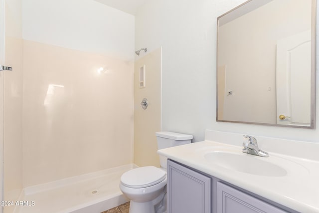 bathroom featuring a shower, vanity, and toilet