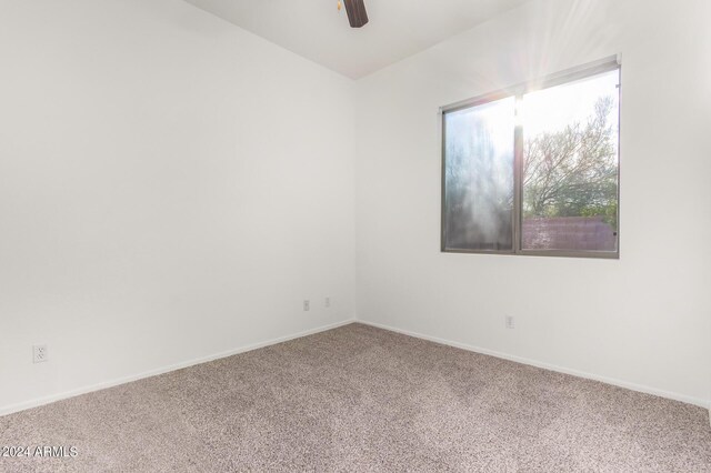 carpeted spare room featuring ceiling fan