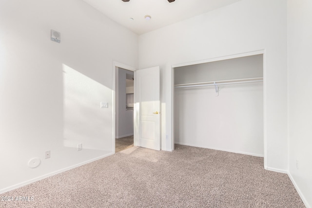 unfurnished bedroom featuring carpet, ceiling fan, and a closet