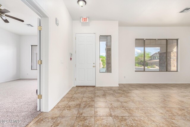 foyer featuring ceiling fan and light colored carpet