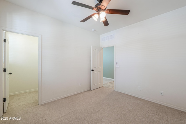 carpeted empty room featuring baseboards, ceiling fan, and visible vents