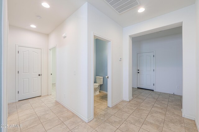 hall with baseboards, visible vents, recessed lighting, and light tile patterned floors