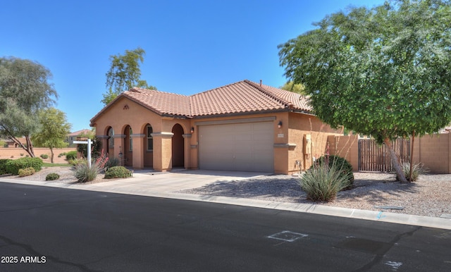 mediterranean / spanish-style home featuring stucco siding, fence, an attached garage, a tiled roof, and driveway