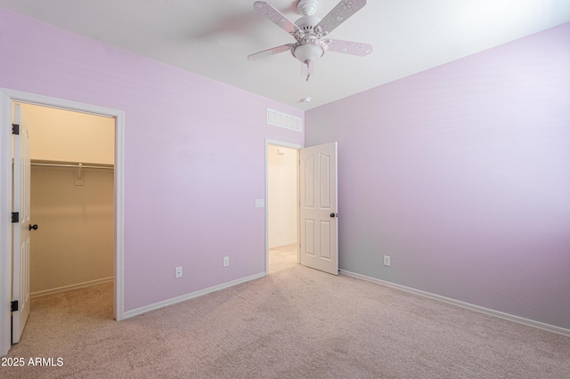 unfurnished bedroom featuring baseboards, a closet, carpet floors, and a spacious closet