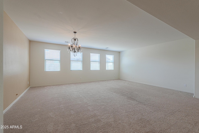 empty room with baseboards, carpet flooring, and a chandelier