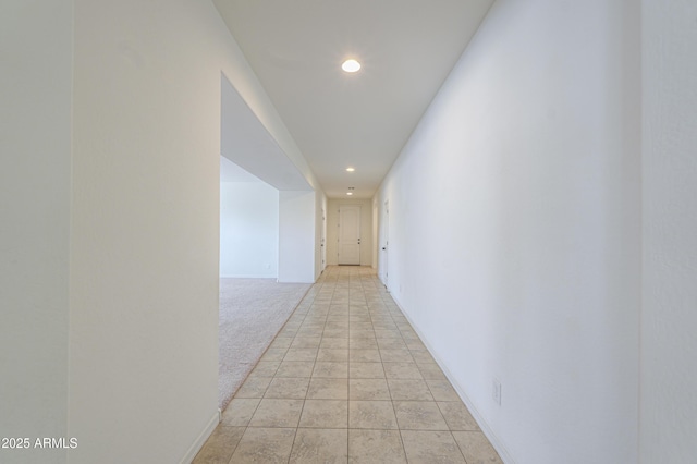 corridor with baseboards, light colored carpet, and recessed lighting