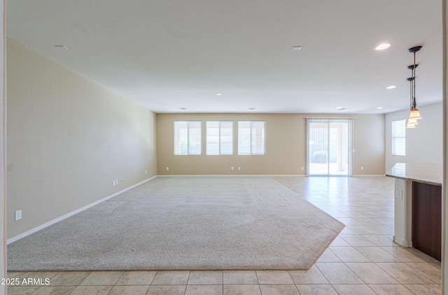 empty room with light tile patterned floors, baseboards, and recessed lighting