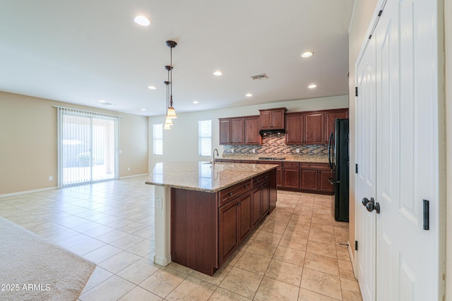 kitchen with visible vents, decorative backsplash, light tile patterned floors, and freestanding refrigerator