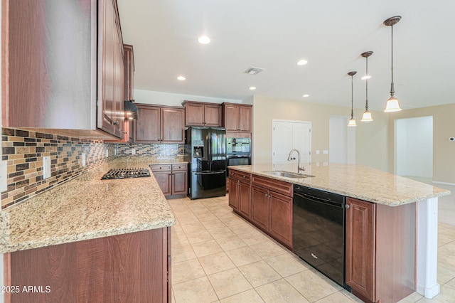 kitchen with a sink, a kitchen island with sink, visible vents, black appliances, and decorative backsplash