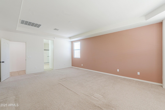 empty room featuring light carpet, baseboards, and visible vents