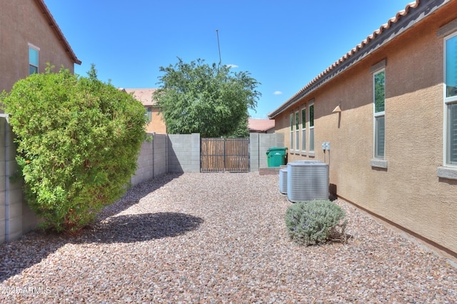 view of yard with fence and central AC unit