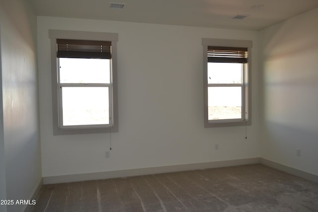 unfurnished room featuring carpet, visible vents, and baseboards