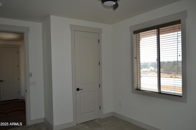 unfurnished bedroom with carpet flooring and baseboards