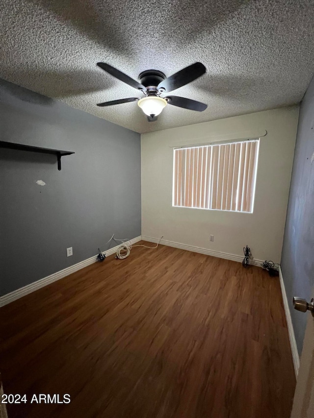 unfurnished room with a textured ceiling, hardwood / wood-style flooring, and ceiling fan