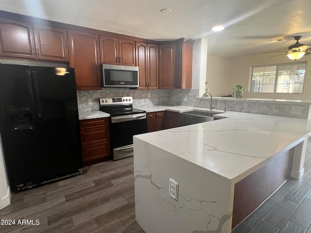 kitchen with sink, dark wood-type flooring, stainless steel appliances, and kitchen peninsula