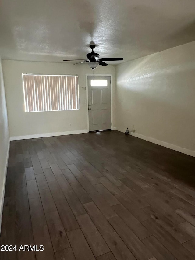 foyer entrance featuring a wealth of natural light, dark wood-type flooring, and ceiling fan