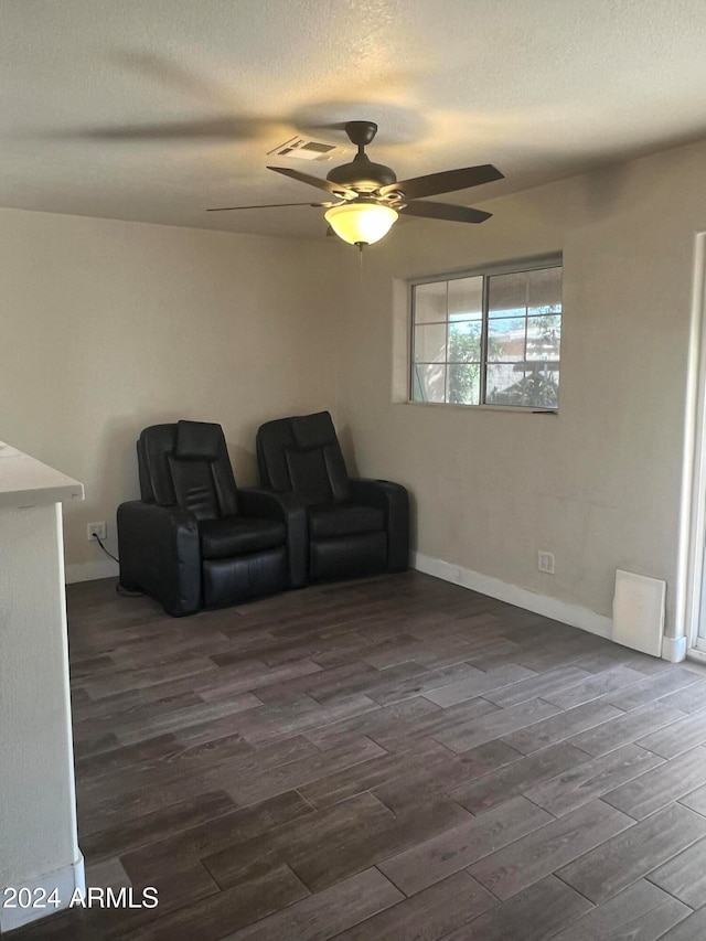 living area featuring a textured ceiling, ceiling fan, and dark hardwood / wood-style flooring