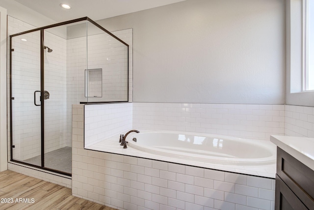 bathroom with vanity, hardwood / wood-style floors, and separate shower and tub