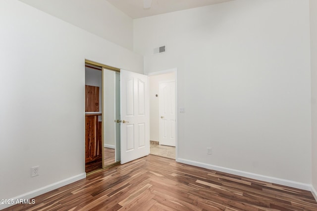 15009 E Palomino Blvd, Fountain Hills, AZ 85268 - unfurnished bedroom featuring wood finished floors, a towering ceiling, and a closet