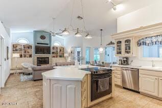 15009 E Palomino Blvd, Fountain Hills, AZ 85268 - kitchen with stainless steel dishwasher, glass insert cabinets, a glass covered fireplace, a center island, and light countertops