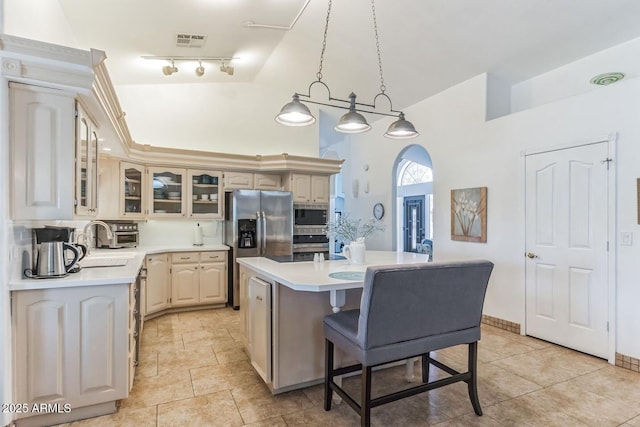 15009 E Palomino Blvd, Fountain Hills, AZ 85268 - kitchen with appliances with stainless steel finishes, a center island, light countertops, glass insert cabinets, and a high ceiling