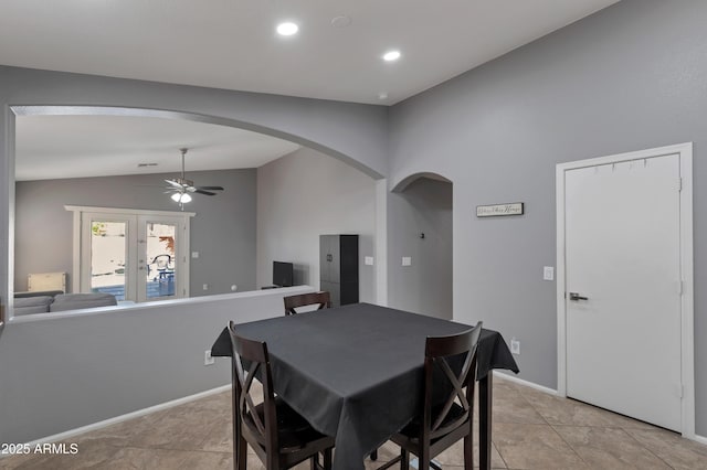 dining area featuring arched walkways, ceiling fan, lofted ceiling, and light tile patterned floors