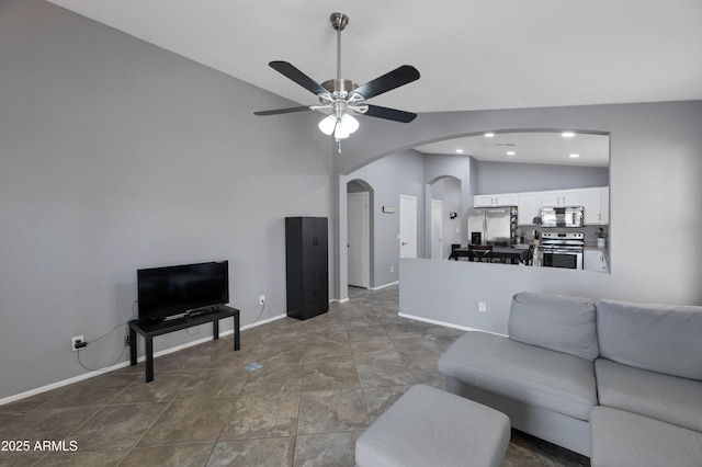 living area featuring ceiling fan, arched walkways, vaulted ceiling, baseboards, and recessed lighting