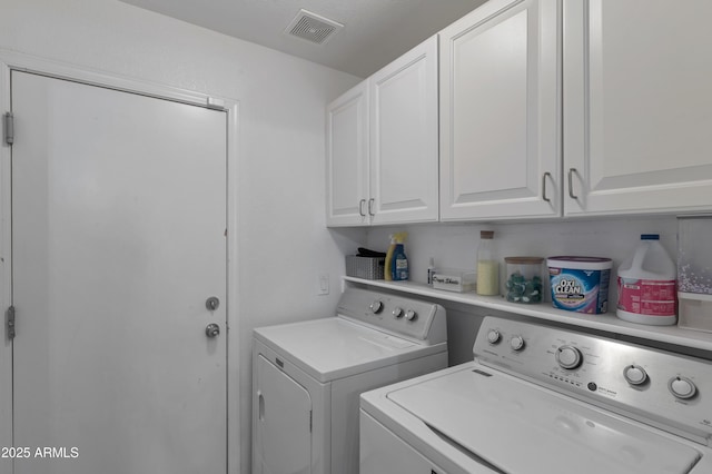 laundry area with cabinet space, independent washer and dryer, and visible vents