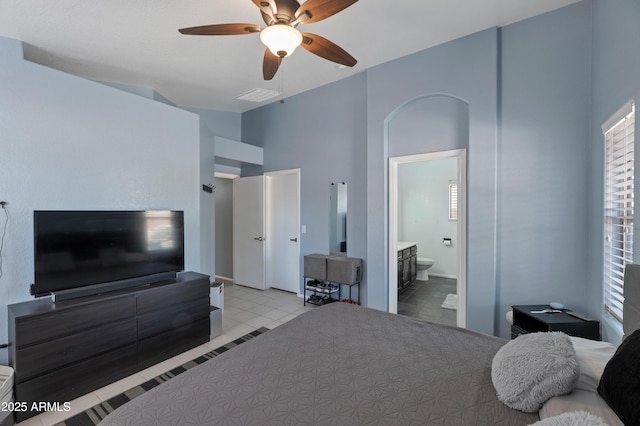 bedroom featuring ensuite bath, ceiling fan, visible vents, and a towering ceiling