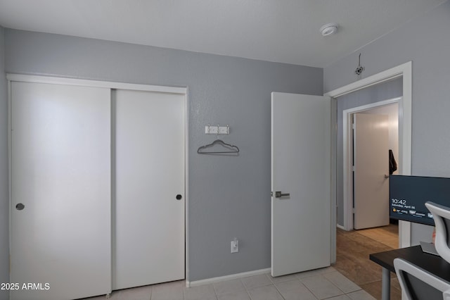 bedroom with a closet and light tile patterned flooring